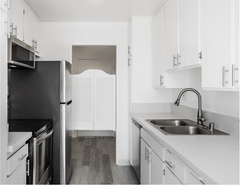 a kitchen with white cabinets and a sink and a refrigerator