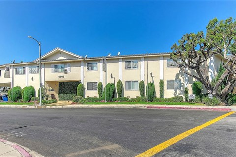 Apartment complex with a tree in front.