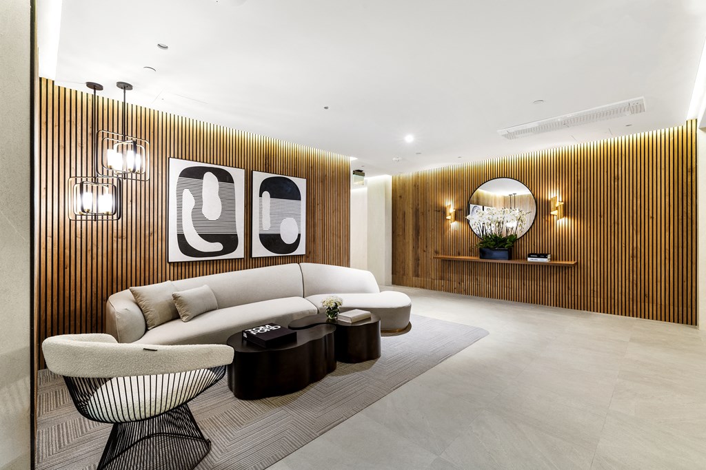 a living room with white furniture and a wooden wall