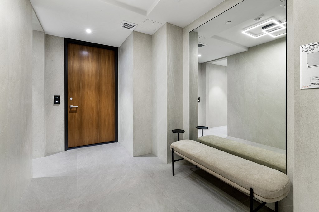 a corridor with a wooden door and a bench in a lobby