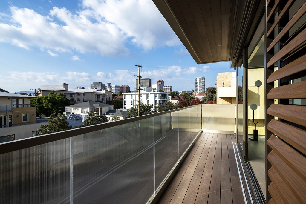 a view of the city from the balcony of a house with a wooden deck