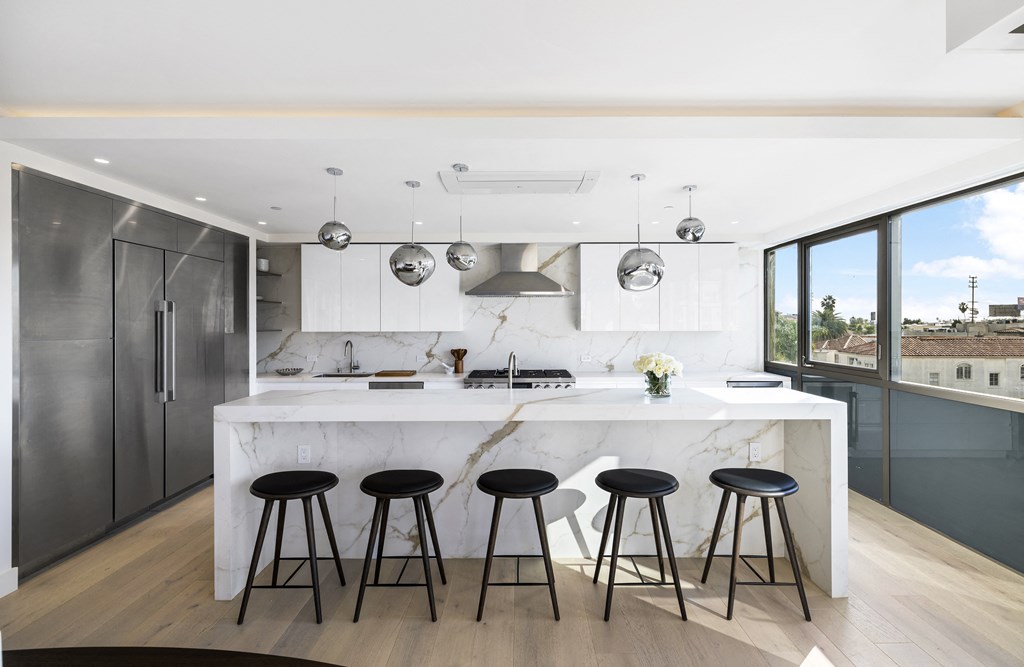 a kitchen with a marble counter top and bar stools