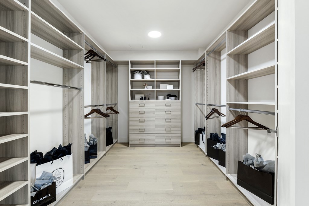 a walk in closet with a large amount of shelving