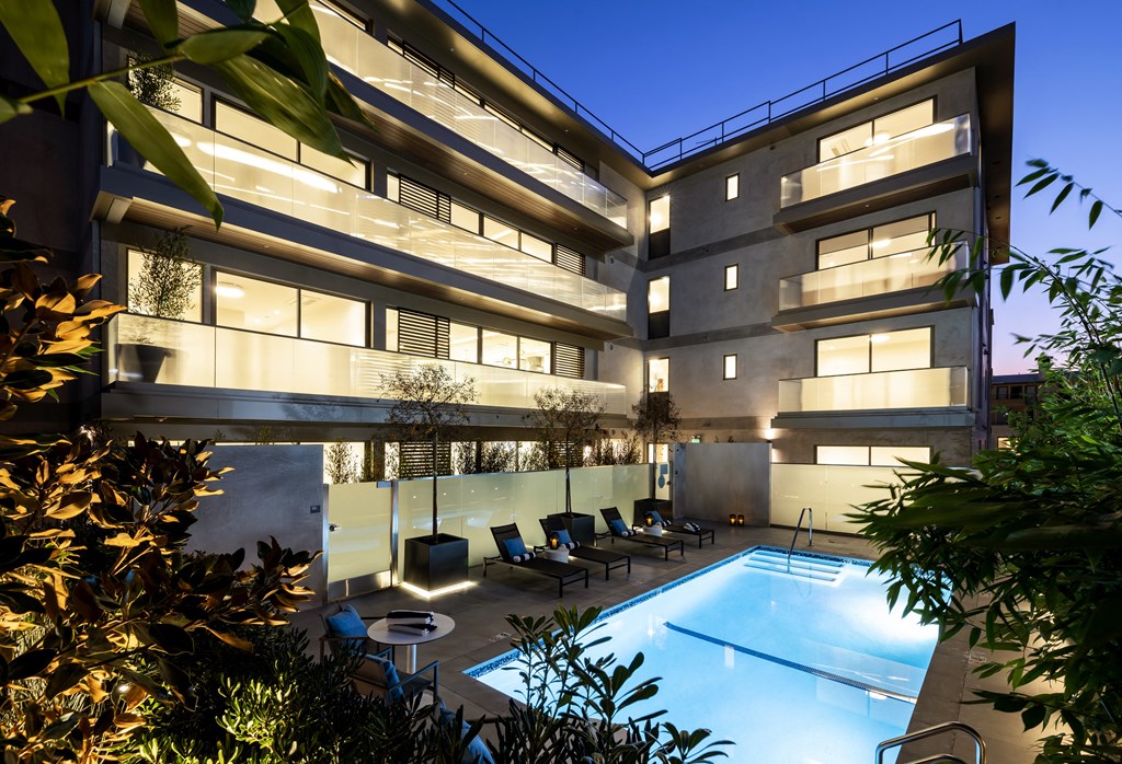 an apartment building with a pool in front of it