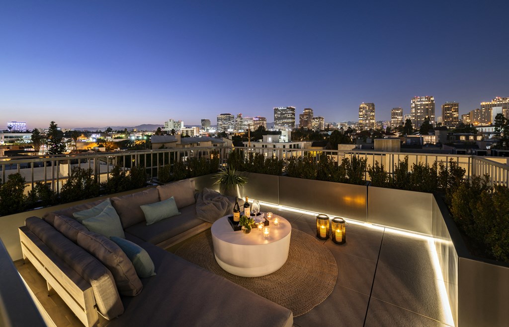 a rooftop terrace with a city skyline at night