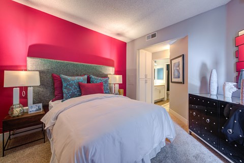 a bedroom with a large bed and a dresser in front of it