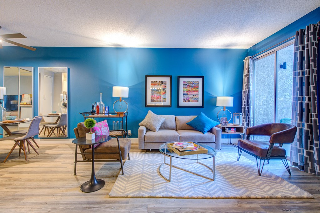 a living room with blue walls and wood floors