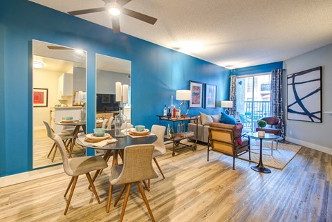 a living room with blue walls and a dining room table and chairs