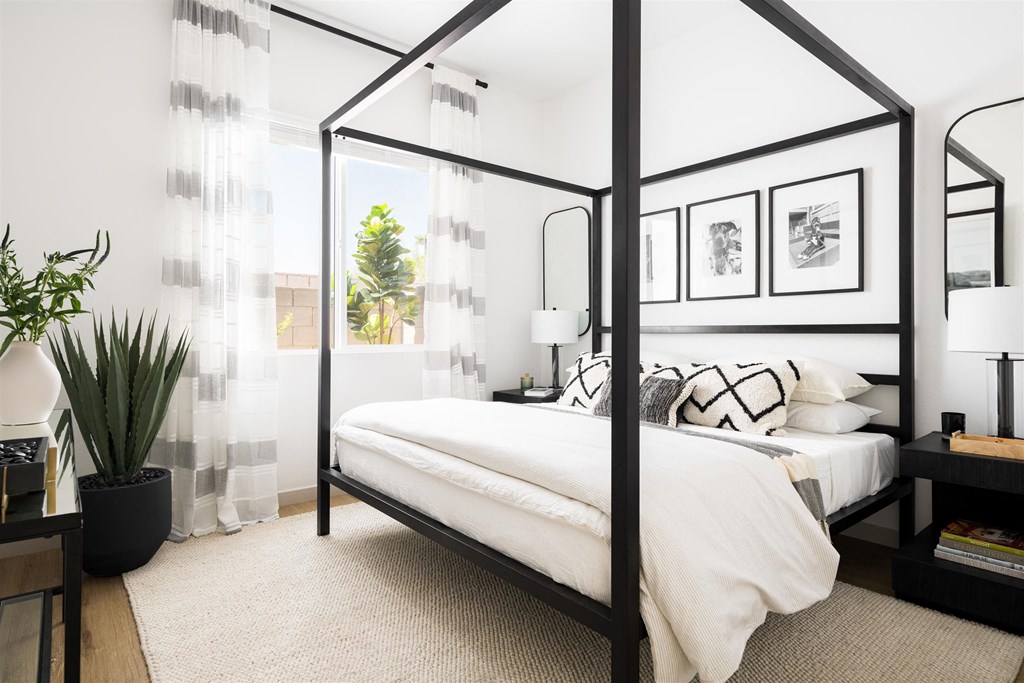 a bedroom with a bed and a black canopy bed