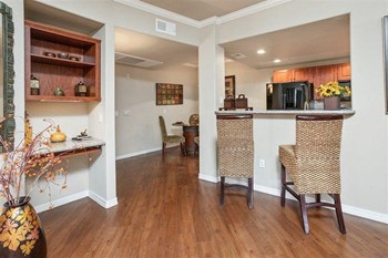 Superstition Canyon Model Kitchen Area Photo of a model apartment showing a breakfast bar and two bar stools. The dinning are and dinning table are seen in the back. - Photo Gallery 5