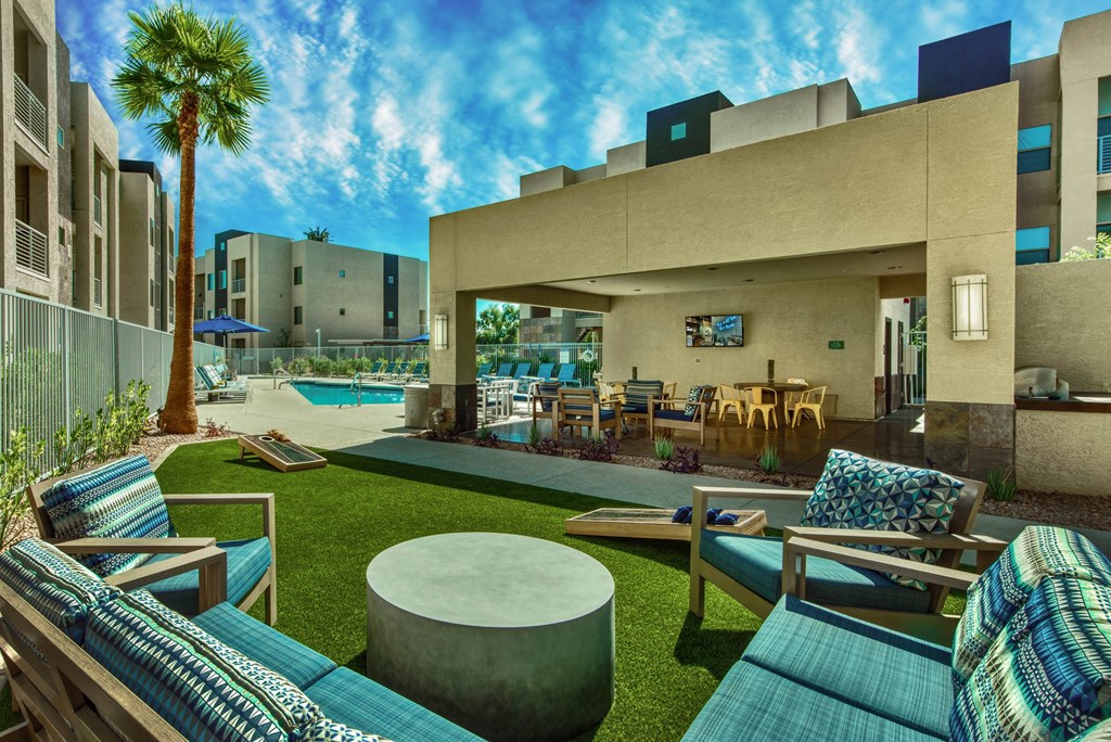 A modern outdoor seating area with a pool and palm tree.