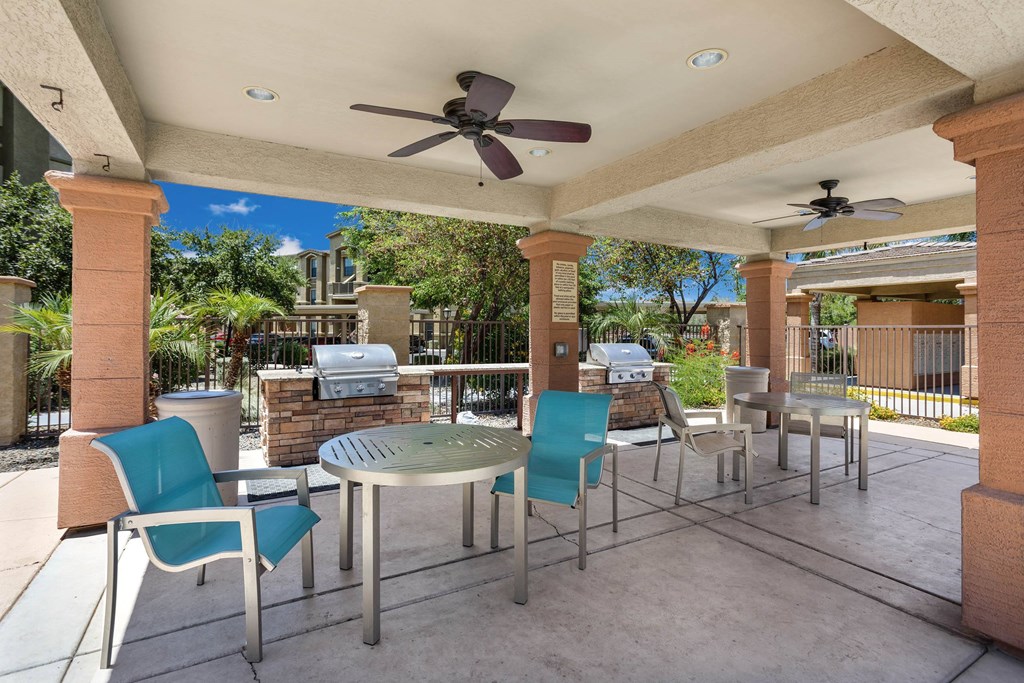 A patio with a table and chairs under a roof.