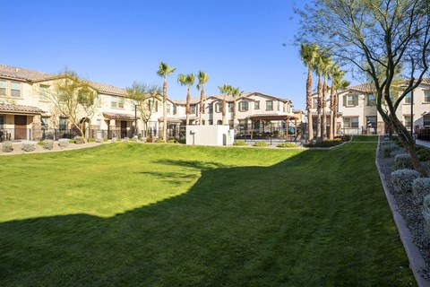 A large grassy area in front of a row of houses.