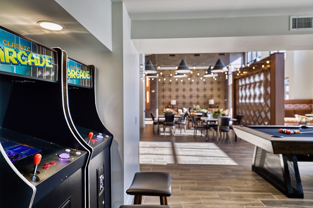 a clubhouse with a pool table and arcade games