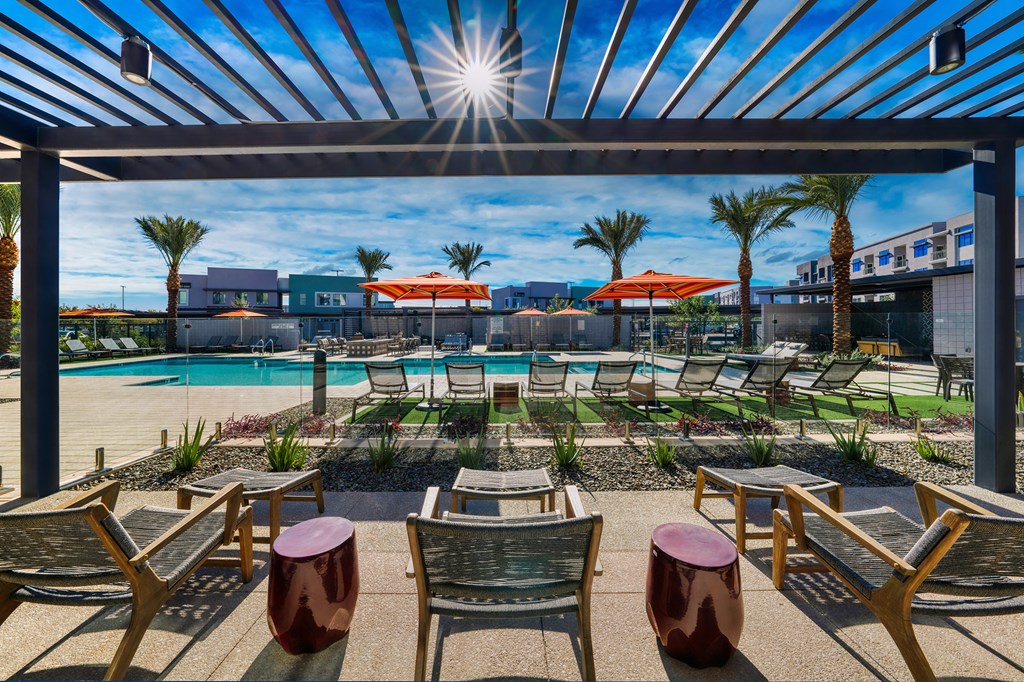 an outdoor patio with tables and chairs and a pool