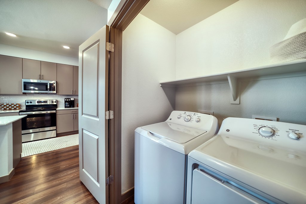 a washer and dryer in a laundry room with a door to a kitchen