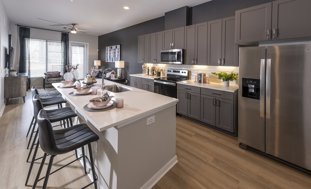 Icon at Cooley Station-apartment kitchen with stainless steel appliances and a large island with stools