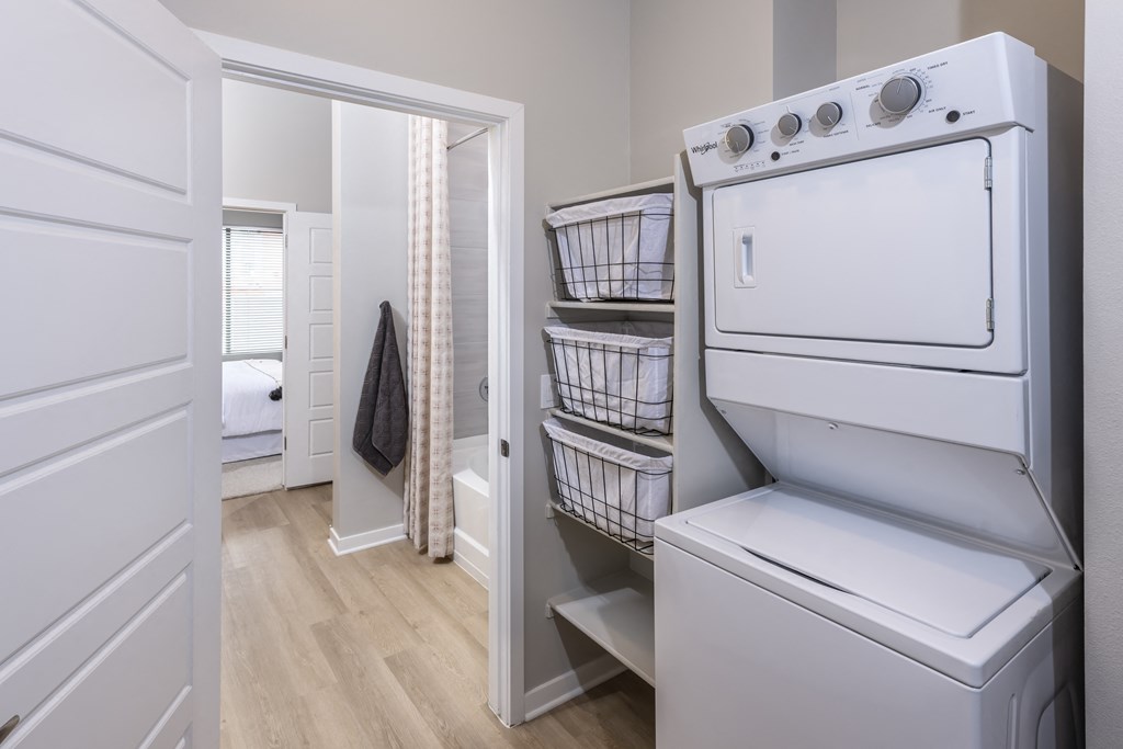 Icon at Cooley Station-apartment laundry room with a washer and dryer and a door to a bedroom