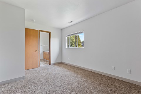 a bedroom with white walls and carpet