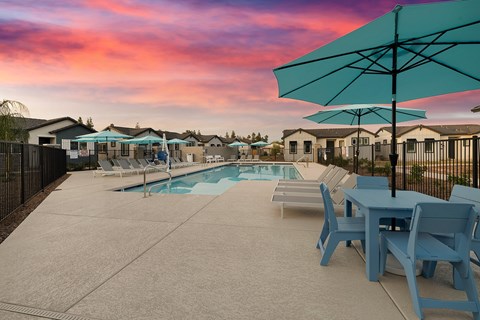 a swimming pool with blue tables and chairs and umbrellas a swimming pool with blue tables and chairs and umbrellas at Villas on Ash, Arizona