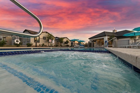 a large swimming pool with a sunset in the background at Villas on Ash Apartments, Gilbert, AZ, 85234
