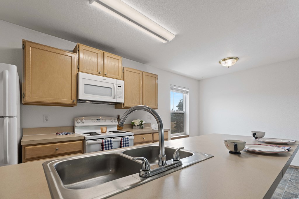 a kitchen with wooden cabinets and a stainless steel sink