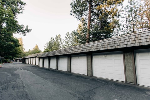 a row of garages with white garage doors and a roof