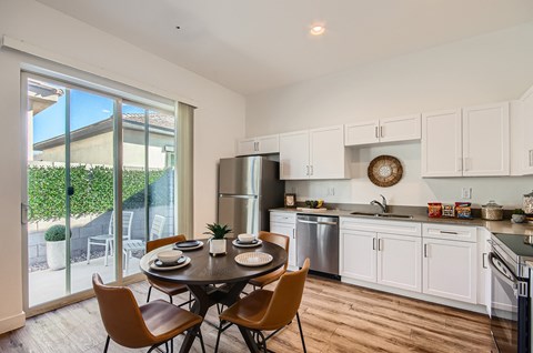 A modern kitchen with a dining table set for four.