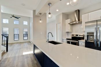 A modern kitchen with a large island and stainless steel appliances.