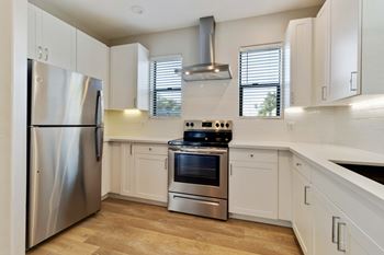 A modern kitchen with stainless steel appliances and white cabinets.
