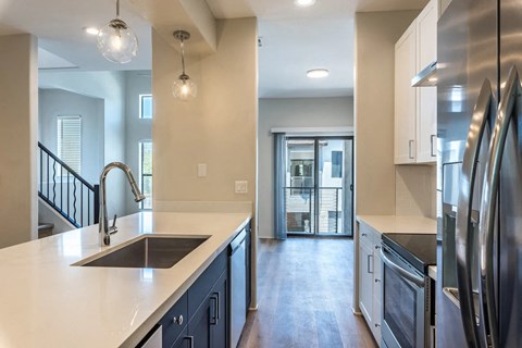 a kitchen with a sink and a stainless steel refrigerator