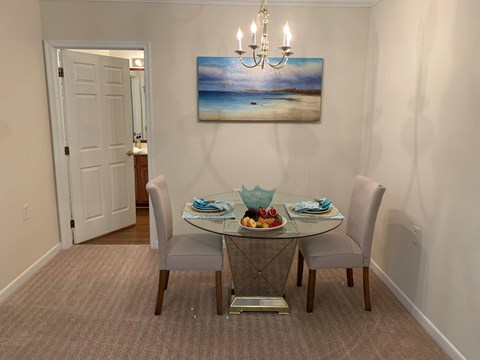 A dining room with a glass table and chairs.