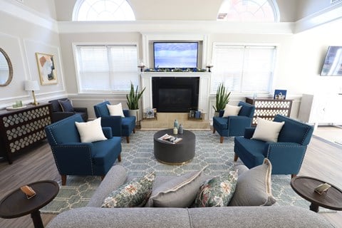 a living room with blue couches and chairs and a fireplace