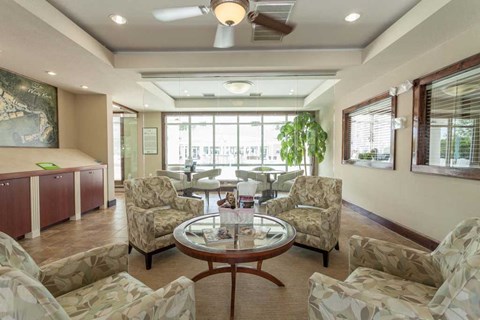 A living room with a table surrounded by chairs.