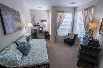 a living room with a couch and a chair and a window