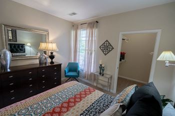 a bedroom with a bed and a dresser and a window