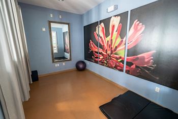 a room with a large painting on the wall and a black ball on the floor