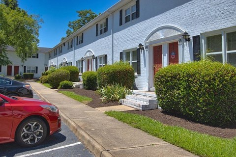 A red car is parked on the side of a street.