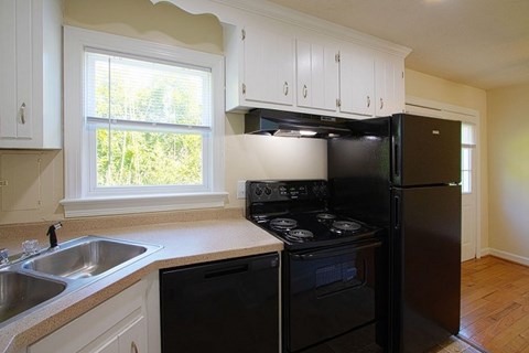 A black stove and oven in a kitchen with white cabinets.