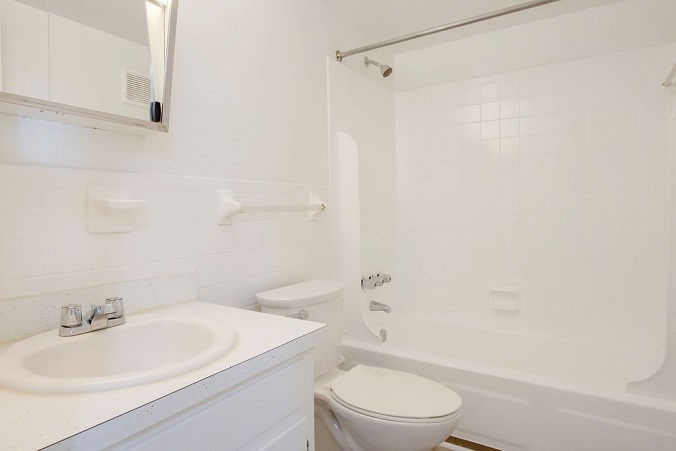 A white bathroom with a sink, toilet, and bathtub.