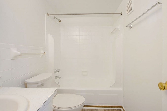 A white bathroom with a toilet, sink, and bathtub.