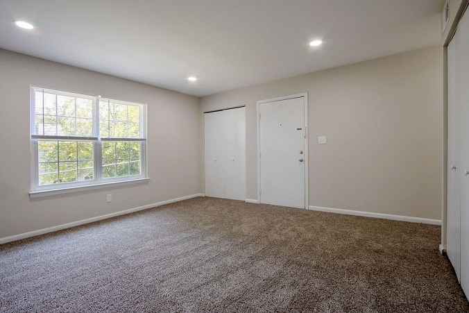 A room with carpeted floor and a window.