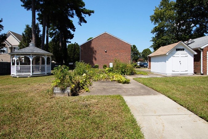 A white gazebo is in the middle of a grassy area.