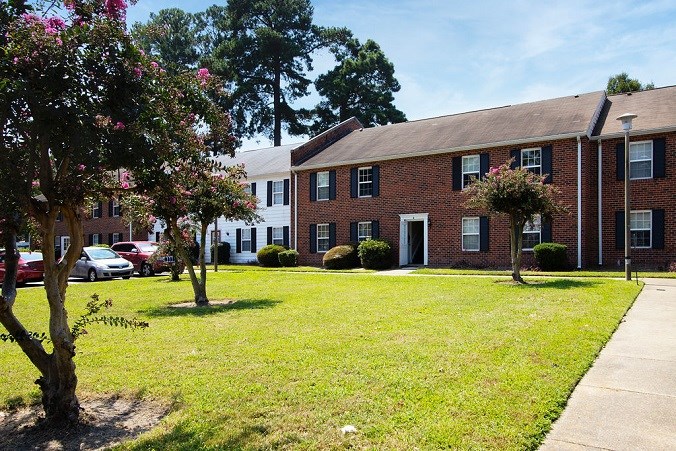 A red brick building with a white door and windows.