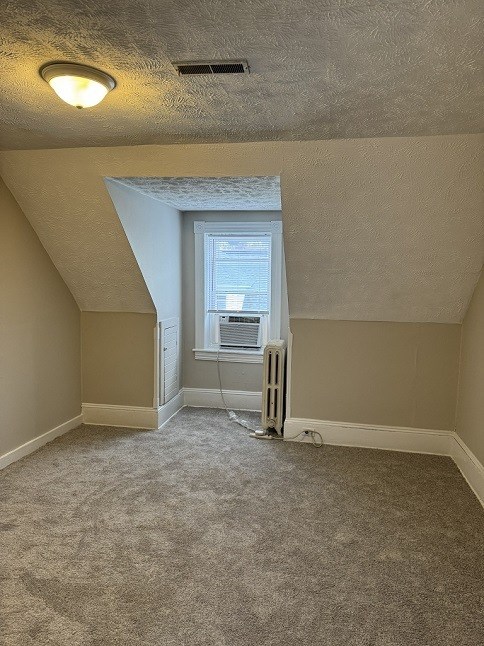 A room with a window and a radiator on the floor.