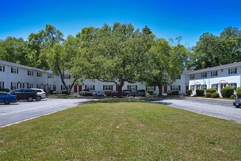A sunny day at a residential area with a grassy lawn and apartment buildings.