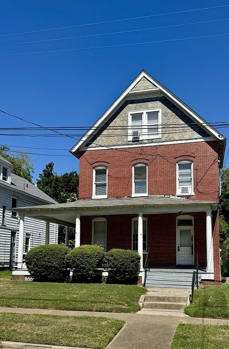A red brick house with a white door and windows.