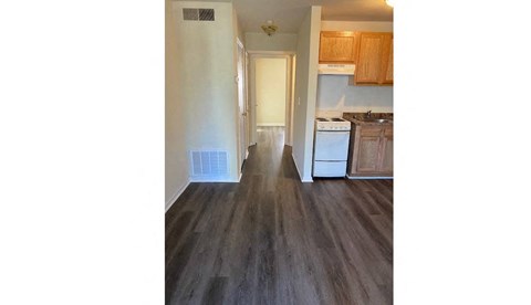 a view of a kitchen and a hallway with wood floors