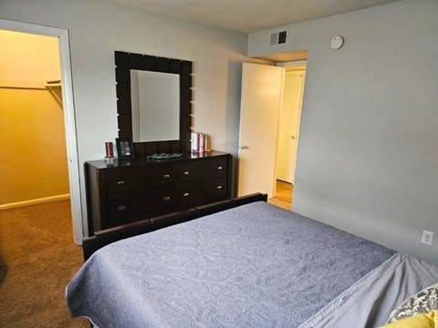 a bedroom with a bed and a dresser with a mirror