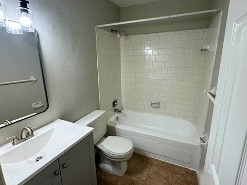 a bathroom with a toilet and a tub and a sink
